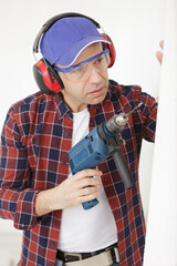 man drilling the wall with drill perforator