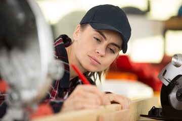 a woman measuring wooden plank