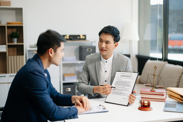 Asian business team and lawyers discussing contract papers sitting at the table. Concepts of law, advice, legal services.