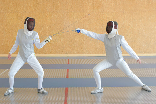 woman and man practicing fencing
