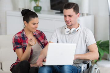 disabled man using laptop sitting next to his girlfriend