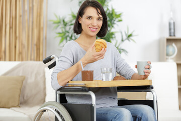 young disabled woman having breakfast smiling at camera