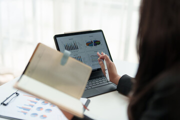 Happy young professional employee sitting at work desk with laptop and paperwork in the interior office of modern company using online computer technology startup business idea.