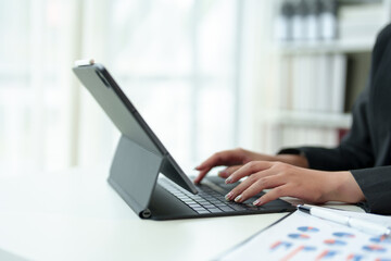 Cropped view of woman's hands typing on laptop computer keyboard and surfing internet on desk, online, work, business and technology, internet network communication concept in office.