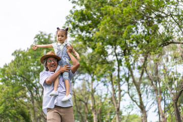 Portrait of happy love asian grandfather and asian little cute girl play and enjoy relax on bed at home.senior, insurance, care.Young girl with their laughing grandparents smiling together.Family