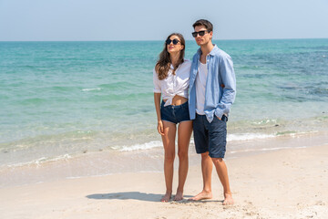 Happy romantic moment couple enjoying sunny day at the beach, man and woman smile and look relaxed,...