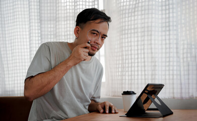 Young businessman employee holding loupe in auditing concept
