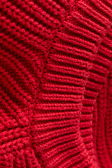 Close up of red knitted texture background, mesh sweater fabric swatch
