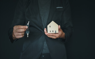 Cropped shot real estate agent holding house key. Insurance or loan real estate concept.
