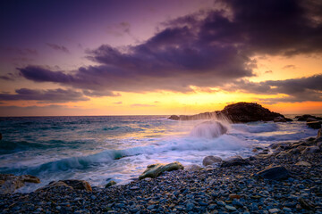 Sea Ocean.  Sunrise time at the sea.  Big roks. Wave hit the rock at beach, sea water splash up to the sky with sun. Sunset Sundown at Sea. Storm.