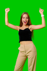 Young Woman Celebrating Success With Raised Fists Against Green Screen Background