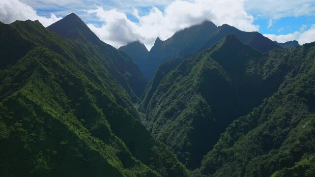 Towering mountain volcano peaks valley Teahupoo Tahiti French Polynesia  Moorea Papeete aerial drone parallax late morning afternoon bluesky daytime sunny clouds stunning island scenery forward