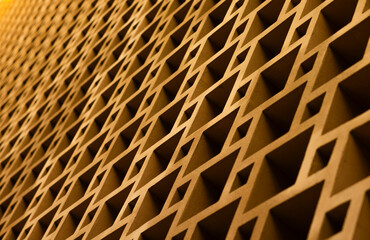 A close-up view of a repeating geometric pattern on a wall. The squares are made of a brown material and create a sense of depth and texture.