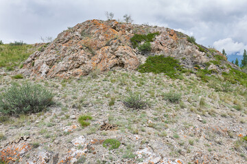 Rocky slope of the mountain against the background of a cloudy sky