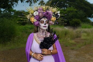 Outdoor portrait of a woman dressed as a catrina. Day of the dead and halloween celebration. Close...