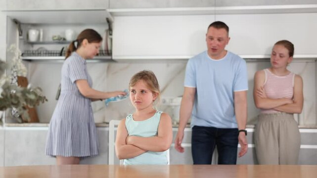 At kitchen parents scold standing daughter for bad behavior, mother clean dish in background. High quality 4k footage
