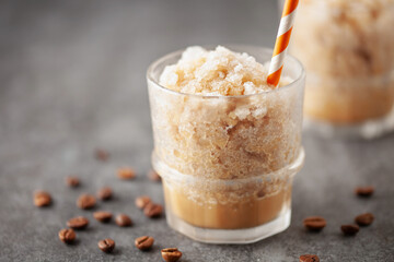 Frozen mocha coffee slushy in a glass on the table. Summer drink concept