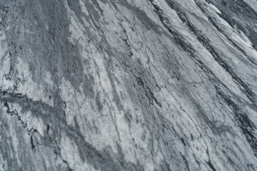 Gray marble texture with natural white veining patterns. Smooth, polished stone surface for countertops