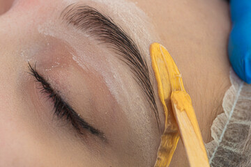 Closeup of An Eye of Caucasain Female During Eyebrow Epilation During Facial Depilation Using Wood...