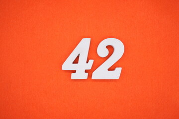 The numbers are made of white painted wood. Placed on the floor was orange paper.