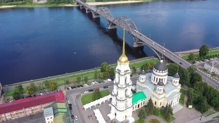 Aerial panoramic view of Rybinsk cityscape overlooking automobile bridge across Volga river and medieval Spaso-Preobrazhensky Cathedral with belfry in historical part of city, Yaroslavl region