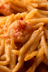 Trofie condite con salsa di gamberetti e bottarga di muggine, pasta italiana, cibo mediterraneo 