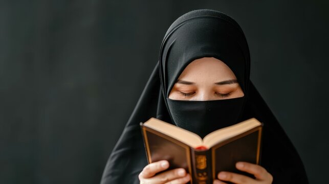 Afghan Muslim woman in burka reading Quran in traditional costume against dark background.