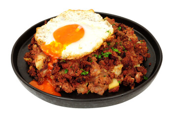 Traditional corned beef hash meal with a fried egg isolated on a white background