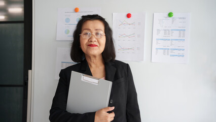 Older smiling 60s asian business woman.woman in office