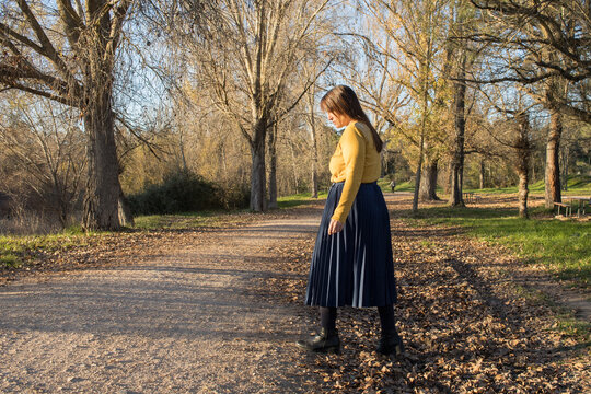 woman walking with mustard 
sweater. in forest Autumn travel vacation concept. holiday. Horizontal. Copy space. Spain