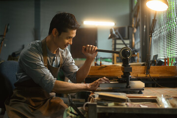 Leather craftsman creating product at his workbench. Small business and Leather craft process concept