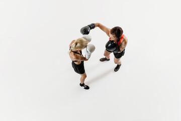 Dynamic boxing scene with two determined female competitors, women in motion, training isolated on...