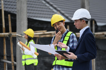 Engineers and businessman planning development details about project at construction site.
