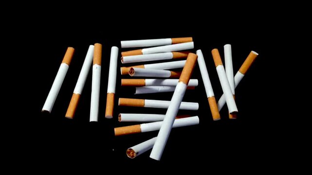 Cigarettes in super slow motion. Flying cigarettes on black background. Stop smoking, quit smoking or no smoking cigarettes