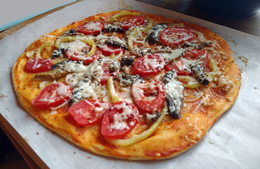 homemade pizza with meat and vegetables on a bright table. taken in close-up