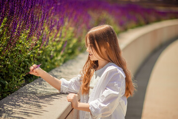 A young girl is basking in the warm rays of the sun, enjoying the beauty of the park, overgrown...