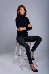 Studio shot of a mid aged woman sitting against isolated background