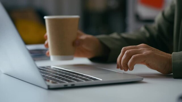 Clumsy female office worker accidentally spilling coffee on laptop during work