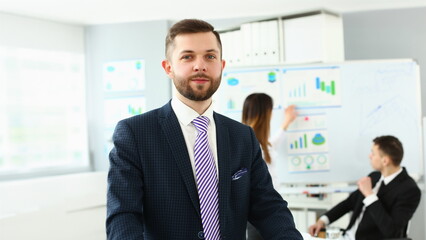 Portrait of businessman at office in presentable suit, colleagues discussing analytical data and statistics. Success, human resources, business, career growth concept
