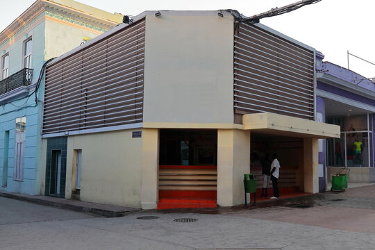 INCIDENTAL, NON RECOGNIZABLE PEOPLE IN THE IMAGE. Chamfer at the Enramadas and General Lacret Streets NE corner, commercial one-story building from the 1950s now a well-known diner. Santiago-Cuba-488