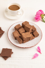 Chocolate marshmallow with cup of coffee on white wooden. side view