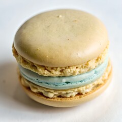 Close up of a blue frosted macaron on white, emphasizing details and colors
