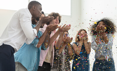 Group of six people friends  in casual dress standing close together, celebrating party and blowing...