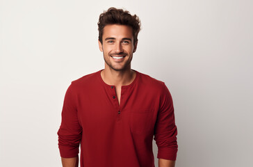 Smiling Man In A Red Shirt Standing Against A Plain Background