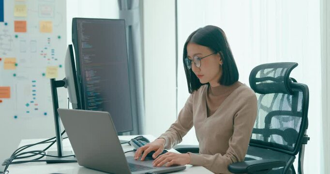 Young adult Asia female freelance eyeglasses typing write prompt AI bot IT app smart program nomad, video game, terminal with coding, user interface, designer, big data center on desktop computer.