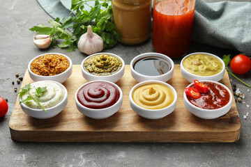 Many different sauces and products on grey table