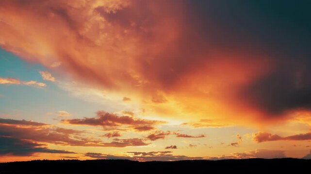 Panning time lapse footage of beautifully illuminated orange rain clouds at dramatic sunset
