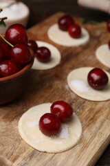 Process of making dumplings (varenyky) with cherries. Raw dough and ingredients on wooden table,...