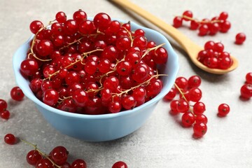 Fresh red currants on light grey table, closeup