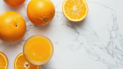 Freshly squeezed orange juice and whole orange on marble surface